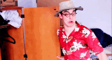 a man wearing a hat and a hawaiian shirt is standing in a closet