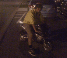 a young boy is riding a motorcycle in a parking lot with a license plate that says ' nc ' on it