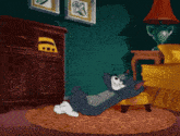 a cartoon of tom laying on the floor with the caption " aji nchofo kda " below him