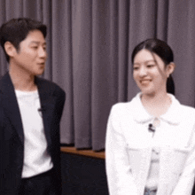 a man and a woman are standing next to each other and smiling .