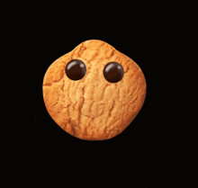 a cookie with chocolate chips on it 's eyes and a smile on it 's face