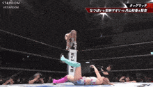 a blurred image of a wrestling match with stardom in the corner