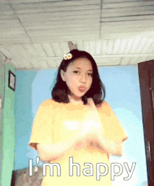 a girl is wearing a yellow shirt and says i 'm happy