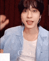 a young man wearing headphones and a blue and white striped shirt with the word cho on it