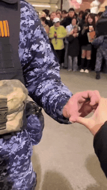 a man in a military uniform holds another man 's hand