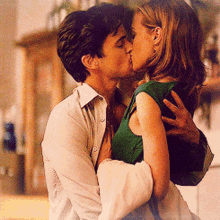 a man and a woman are kissing in a room