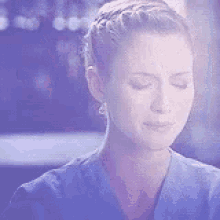 a close up of a woman 's face with her eyes closed in a blue shirt .
