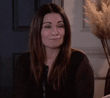 a woman wearing a black shirt is smiling and making a funny face