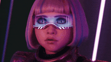a woman with purple hair and futuristic goggles on