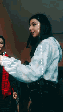 a girl in a blue tie dye hoodie has tiktok on her phone