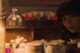 a woman is standing in front of a shelf full of bottles