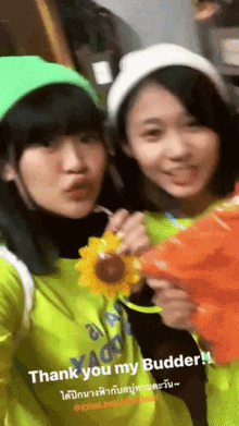 two girls are posing for a picture and one of them is wearing a yellow shirt that says " thank you my budder "