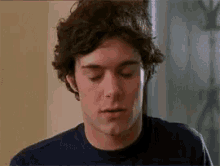 a close up of a man 's face with his eyes closed in a room .