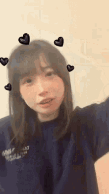 a girl wearing a blue shirt with hearts on her face