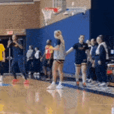 a group of people are playing basketball on a court .