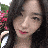 a close up of a woman 's face with a few roses in the background