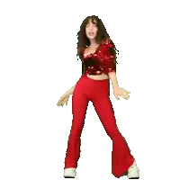 a woman in a red sequined top and red pants is dancing with her arms outstretched