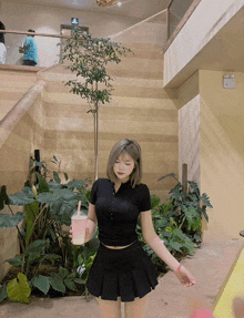 a woman in a black skirt holds a pink drink
