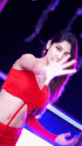 a woman in a red crop top and skirt is dancing