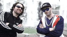 two men standing next to each other one wearing a hat that says supreme