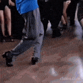 a man in a blue shirt is dancing in a crowd of people .