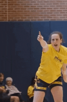 a woman wearing a yellow shirt that says ' inla ' on it
