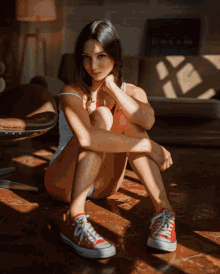a woman is sitting on the floor wearing converse sneakers