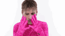 a man is wearing pink gloves and a pink sweater .