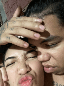 a man kissing a woman on the forehead with a tattoo on his arm that says ' soap '