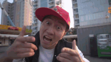a man wearing a red hat that says ' supreme ' on it