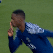 a soccer player wearing a blue qatar airways jersey is running on a field .