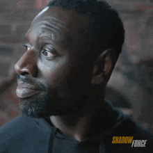 a close up of a man 's face with the words shadow force on the bottom right
