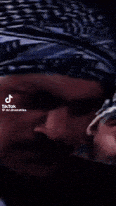 a close up of a man 's face with arabic writing on the bottom right
