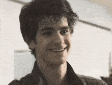 a close up of a young man 's face smiling