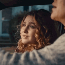 a woman is crying while sitting in a car