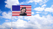 an american flag with a picture of a woman on it against a cloudy sky