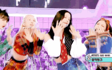 a group of women are dancing on a stage with a sign that says # 0505 on it .