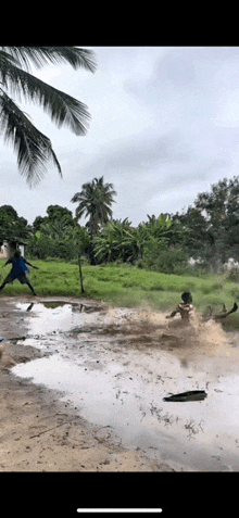 a group of people are playing in a puddle of mud .