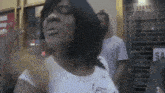 a woman in a white shirt is standing in front of a store with a sign that says sa