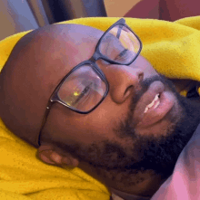 a man with glasses and a beard is smiling