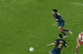 a group of soccer players are celebrating a goal with a crowd behind them .