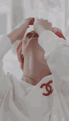 a man wearing a red hat and a white shirt covering his face with his hands