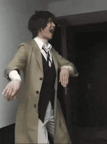 a man in a trench coat and vest is dancing