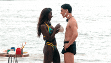 a man and a woman are looking at each other and the woman has white paint on her face