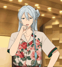 a man with long white hair and a floral shirt