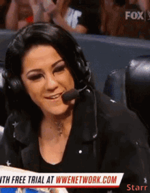 a woman wearing headphones is smiling in front of a sign that says fox