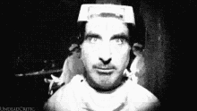 a black and white photo of a man with a white hat on his head .