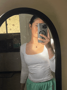 a woman taking a picture of herself in a mirror with a phone that says ' samsung ' on it