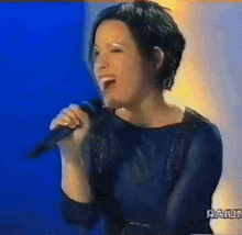 a woman singing into a microphone with the word raiun on the bottom left