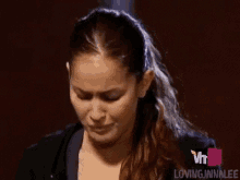a woman is making a funny face while looking down .
